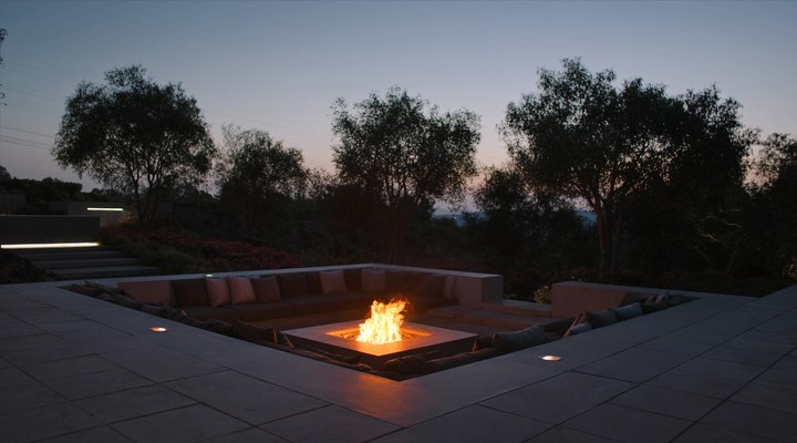 A sleek outdoor lounge area with a modern fire pit and comfortable seating, perfect for modern home additions and patio designs.