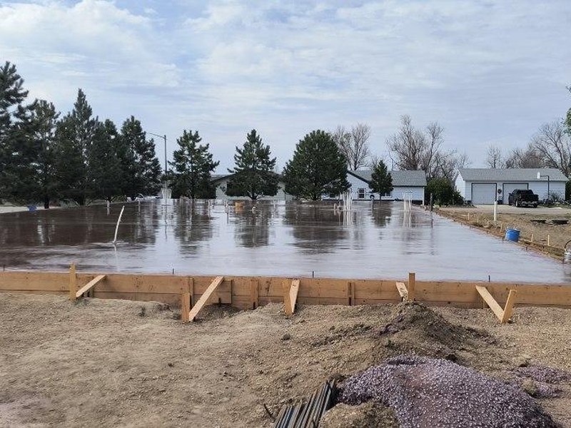 A freshly poured concrete foundation for a residential construction project, highlighting the concrete services offered by Ponderosa Builders LLC.