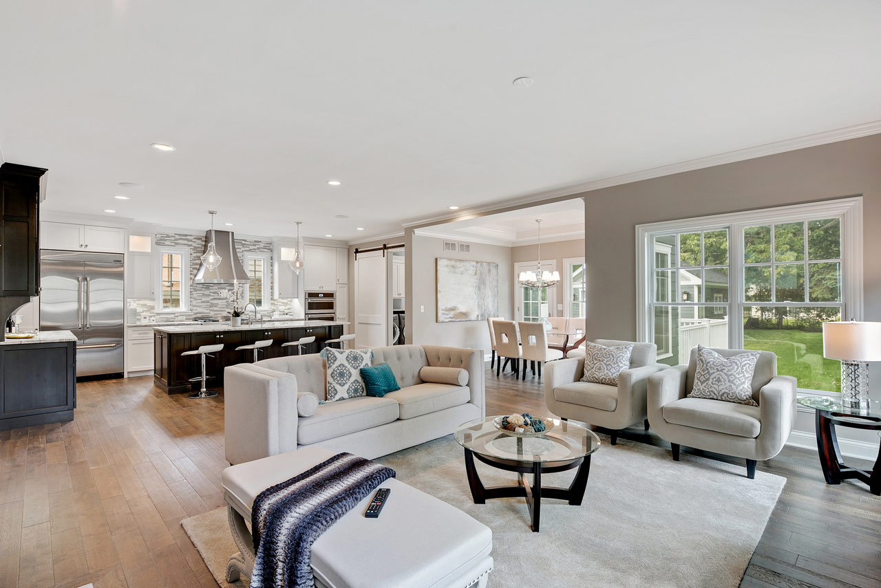 An expansive open concept living space featuring a modern kitchen with bar seating and a cozy living area, perfect for contemporary home designs.
