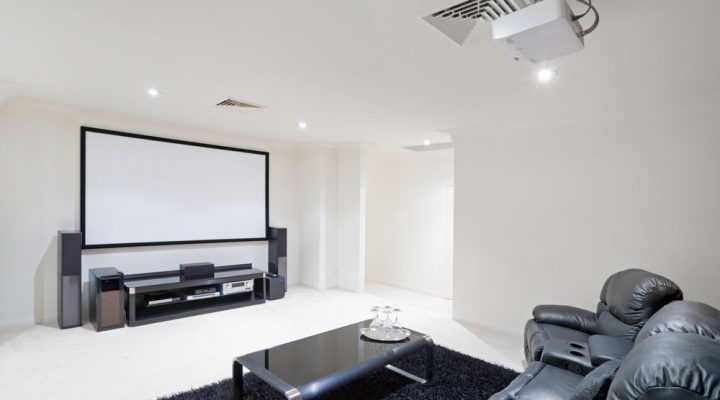 A spacious and modern home theater setup with large screen and comfortable seating, perfect for family entertainment.