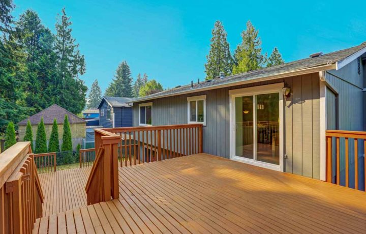 An elevated wooden deck featuring an access to the backyard, perfect for summer barbecues and outdoor gatherings.