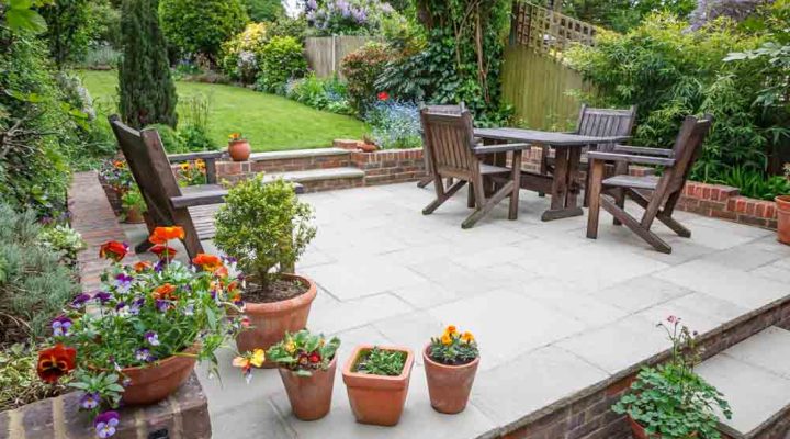 A beautifully arranged garden patio with dining furniture and lush greenery, perfect for outdoor living and entertainment spaces.