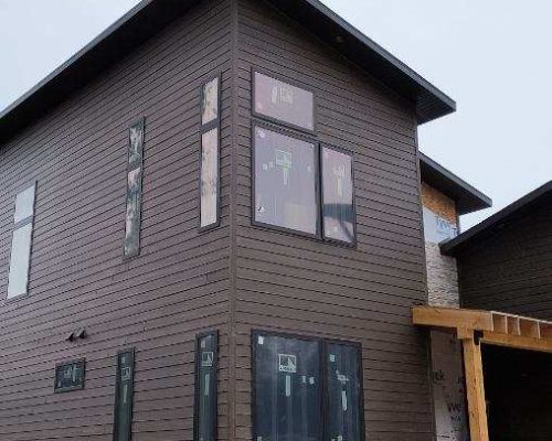 Modern home addition project under construction showcasing large windows and high-quality materials, reflecting the expertise of Ponderosa Builders LLC in modern home designs.