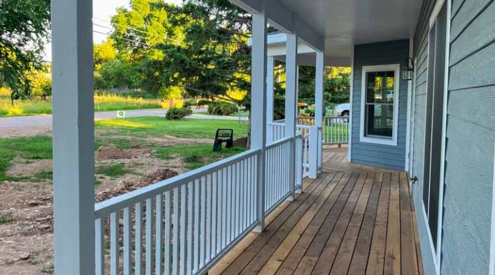 A cozy front porch with wooden decking, illustrating the deck and pergola services available from Ponderosa Builders LLC.
